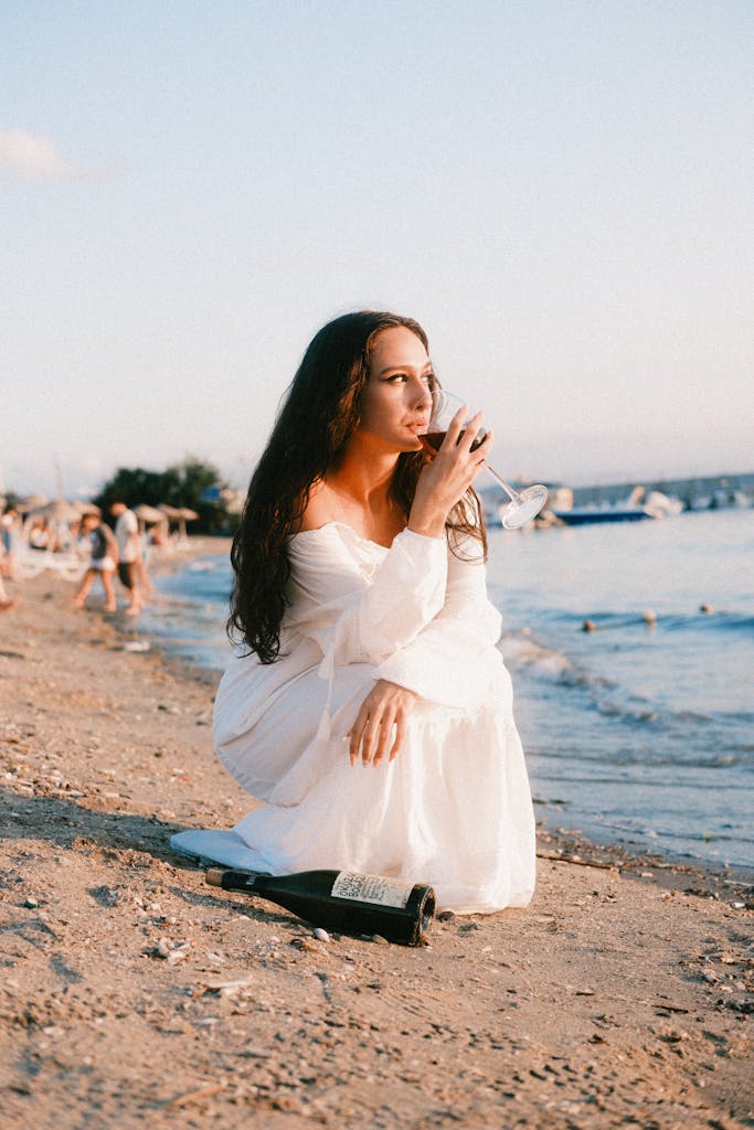 Woman Enjoying Sunset on Beach With Wine